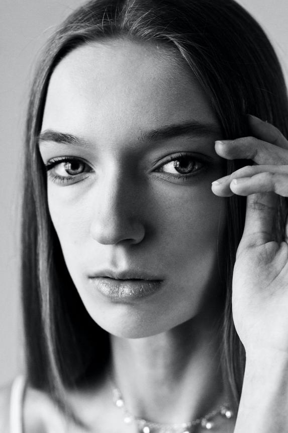 Woman holding hair in close up black and white photo