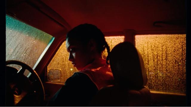 A girl sitting in th car at rainy night