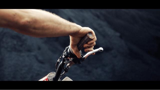 Detail of Sebastien's hand holding the handle-bar