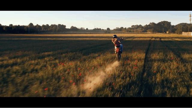 Sebastien driving on his motorbike through a poppy field in Montpellier area