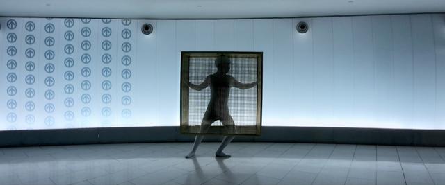 A person dancing in a golden cube cage in Montreal subway