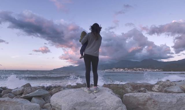 Woman holding a baby on the coastline