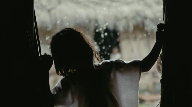 An indigenous child inside during a rain, Colombia