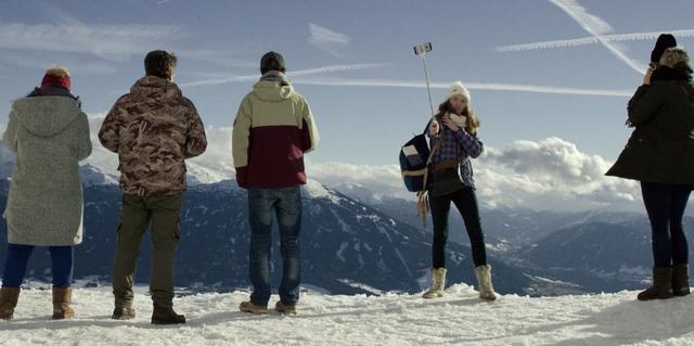 A tourist taking a selfie on the top of Alps in Austria