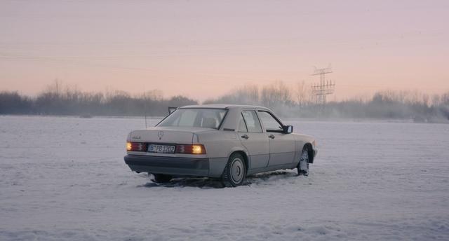 A Mercedez car on a snowy ground during sunset